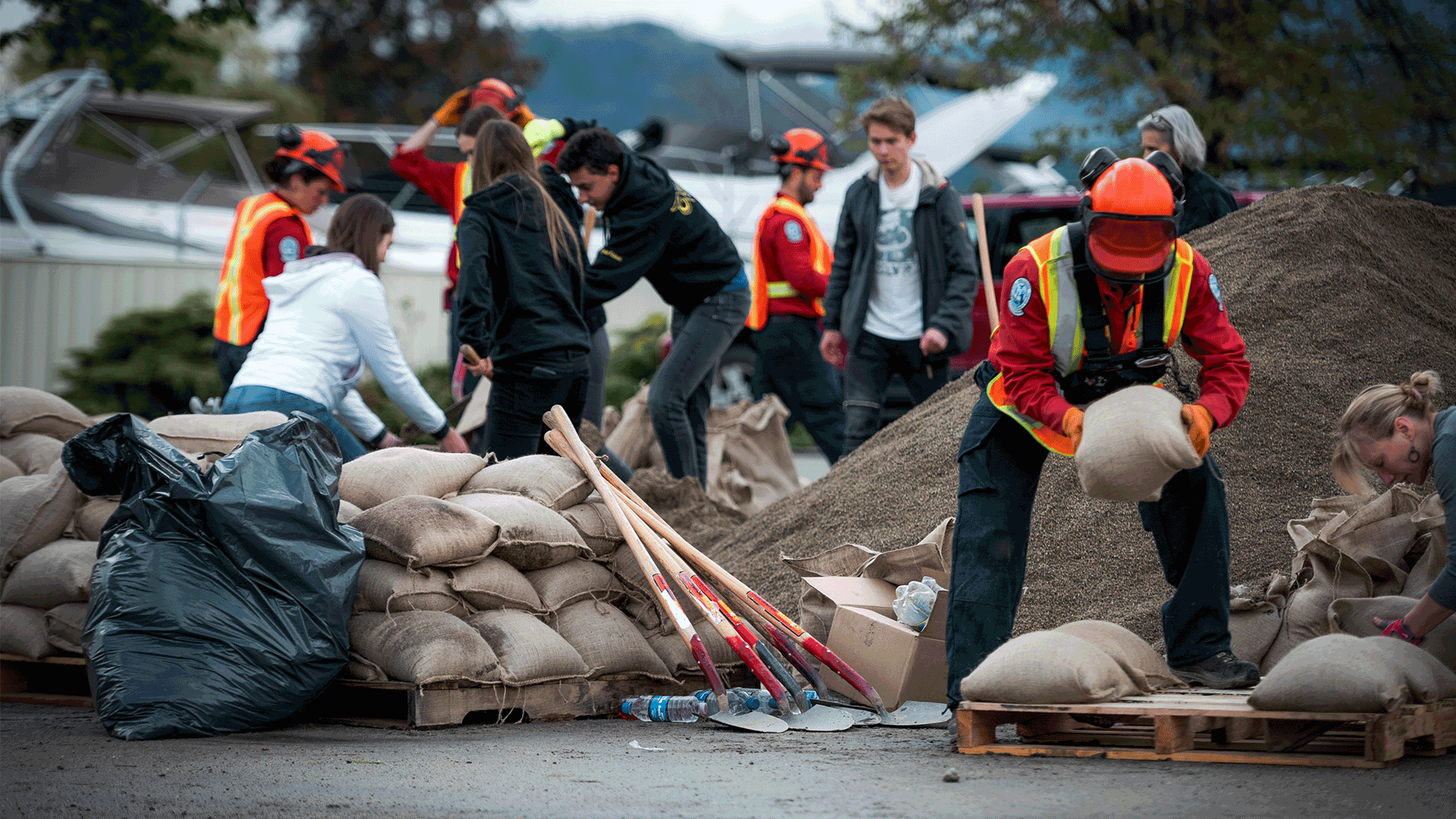 Group of workers creating sandbag wall against flood waters