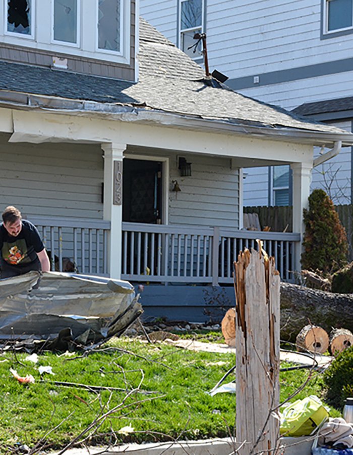 Nashville, Tennessee, 2020: People clean trash from their yard and start to cut a fallen tree the morning after a tornado rips through Nashville.